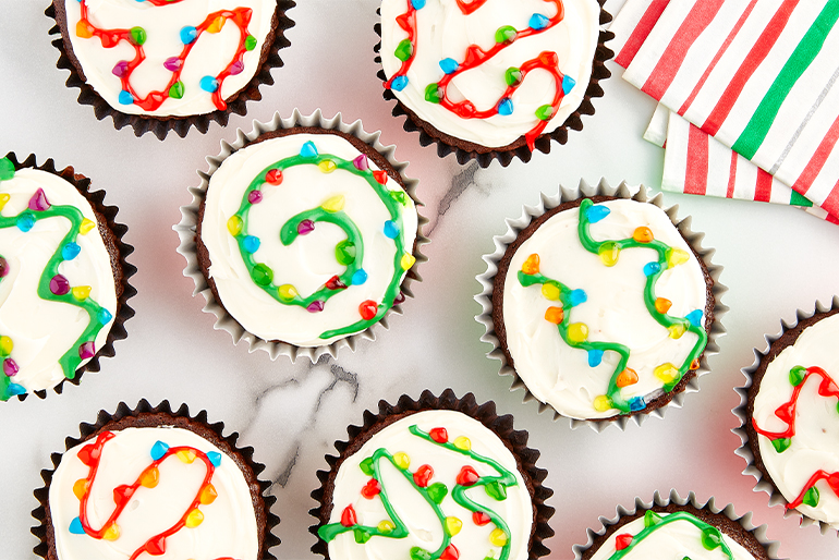 Cupcakes with white frosting decorated as christmas lights