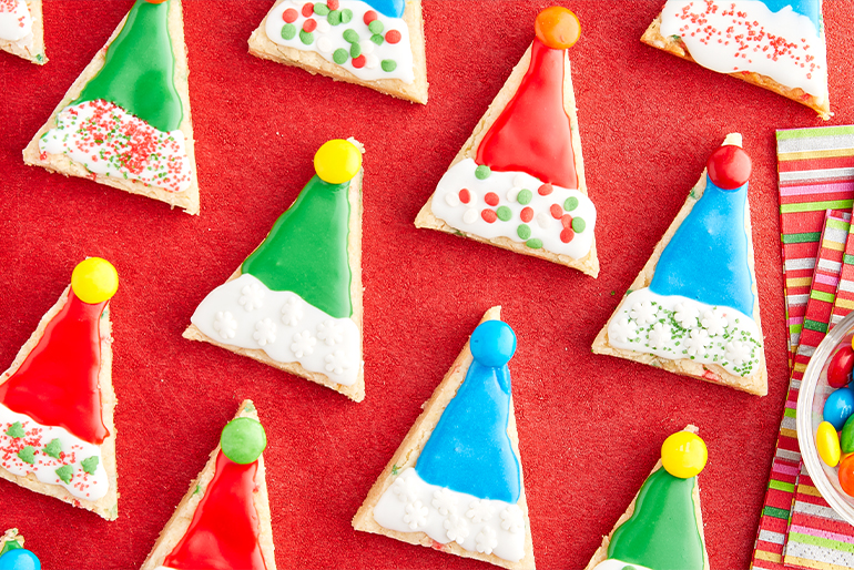 Sugar cookies decorated as elf hats with blue, red and green icing