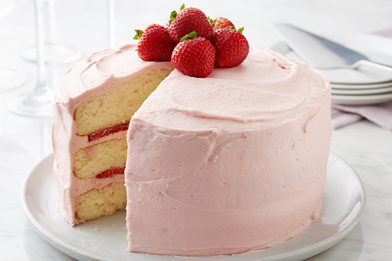 Vanilla cake with strawberry frosting and strawberries on top