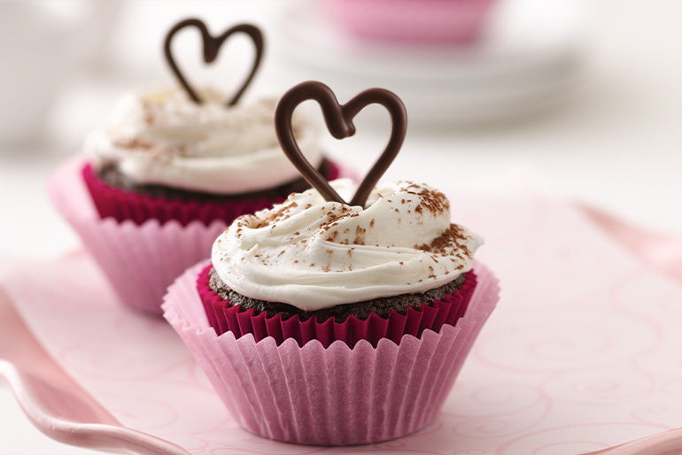 Cupcakes de chocolate con betún de vainilla decorados con un corazón de chocolate