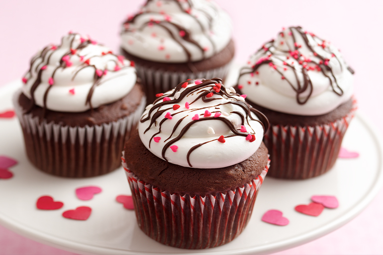 Cupcakes de chocolate con betún blanco y decoración de corazones
