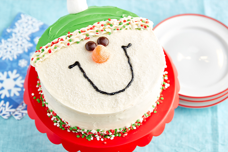 Pastel decorado como muñeco de nieve navideño con sombrero verde